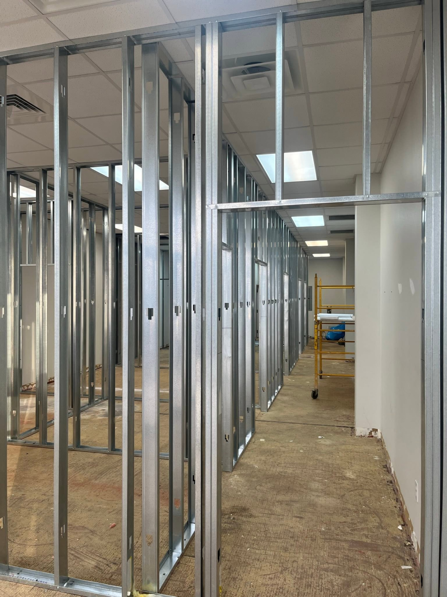 Audibel Houma during construction — metal stud partitions, drop ceiling, and unfinished floor